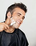 Photo of a man shaving his beard.